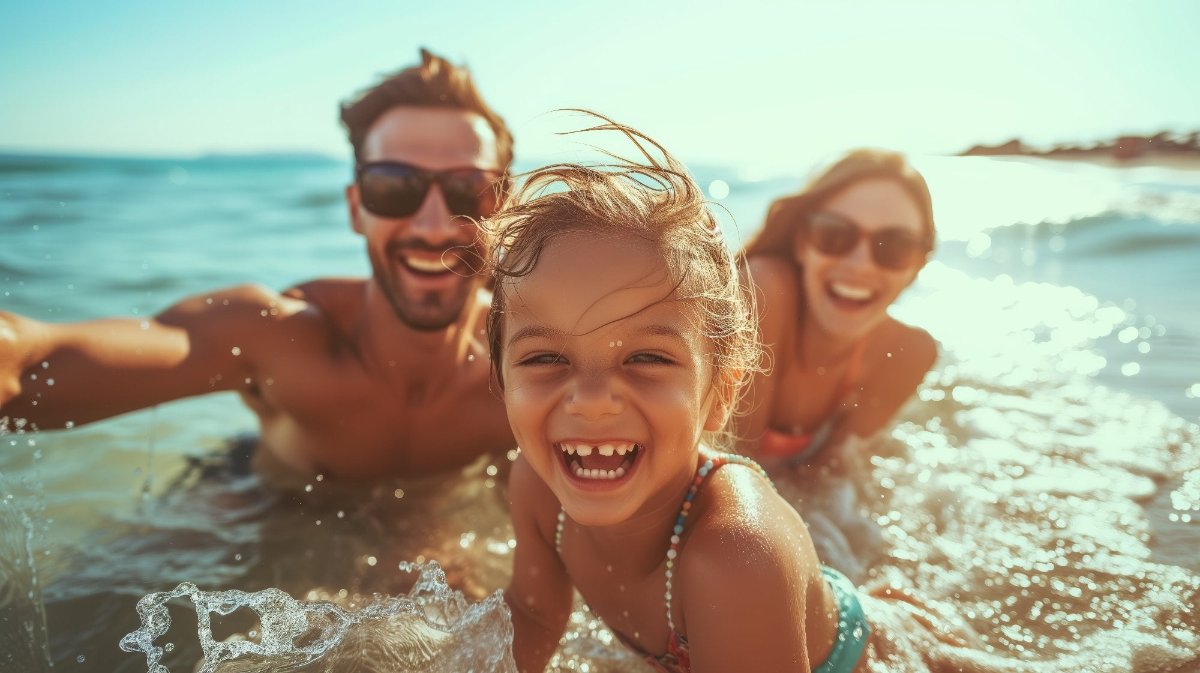 Young family enjoying swimming at the beach